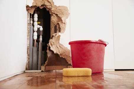 leaking plumbing pipes inside a ripped up wall