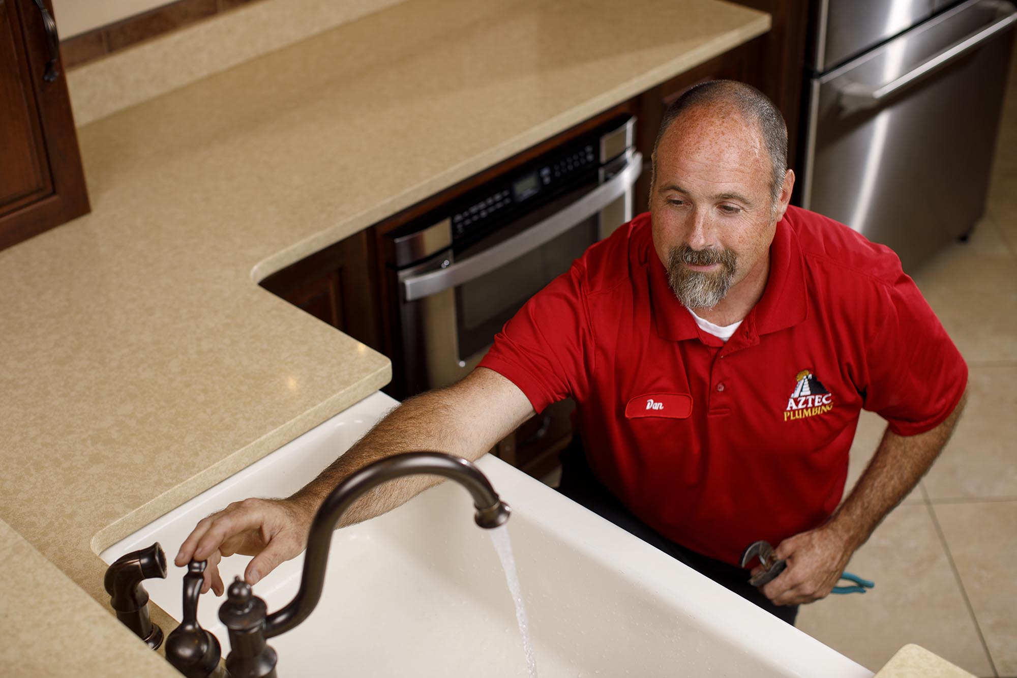 Aztec plumber repairing sink in Venice, FL home